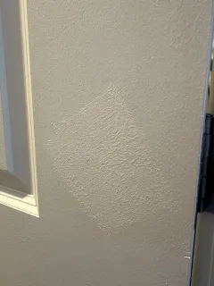 Punch list item photo showing a door frame paint patch needing rework