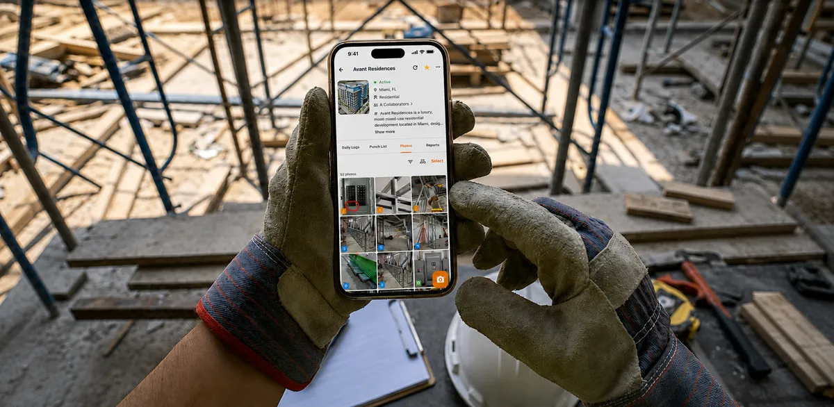 A gloved hand holding a phone on a scaffolded job site, showing a project's photo gallery in OnsiteSync